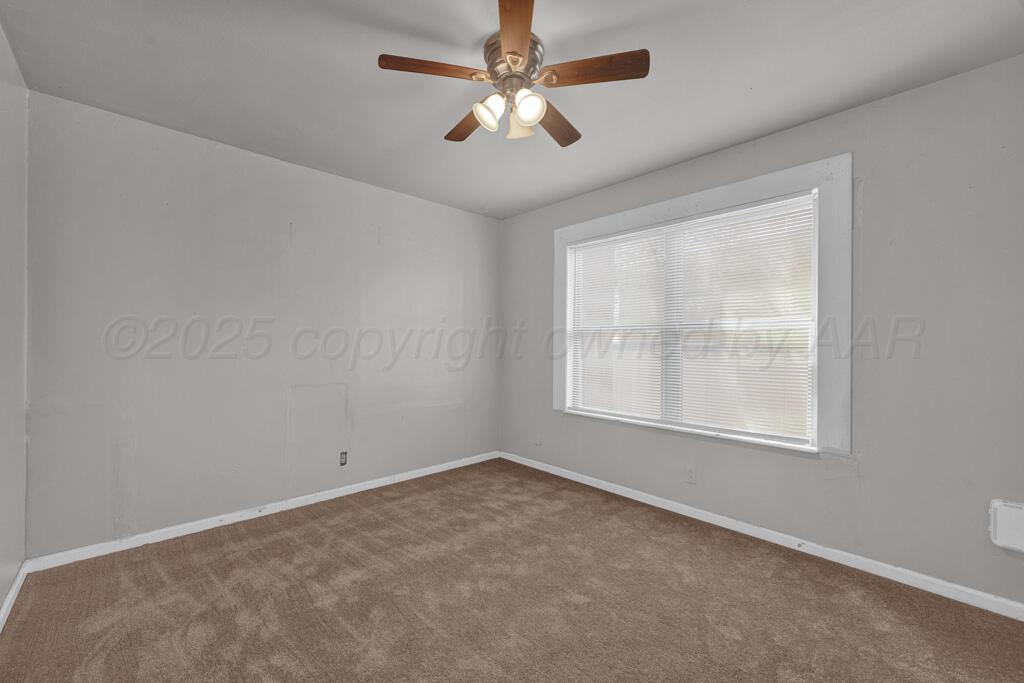 108 Spruce Avenue Dumas, TX 79029 - Photo 11 of 15 an empty room with a window and a fan