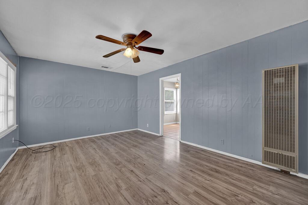 108 Spruce Avenue Dumas, TX 79029 - Photo 4 of 15 wooden floor in an empty room with a window