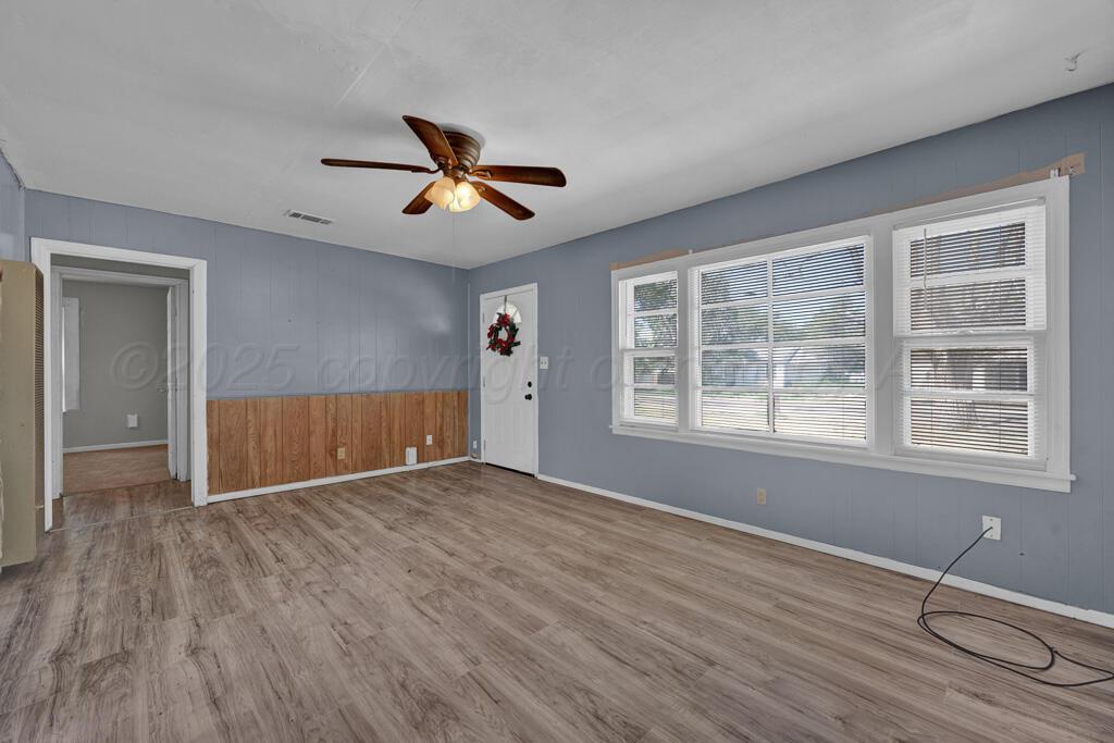 108 Spruce Avenue Dumas, TX 79029 - Photo 5 of 15 a view of empty room with wooden floor and fan