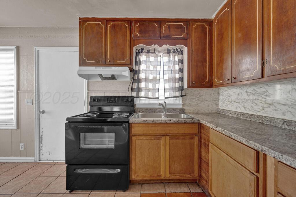 108 Spruce Avenue Dumas, TX 79029 - Photo 6 of 15 a kitchen with stainless steel appliances granite countertop a stove and a sink