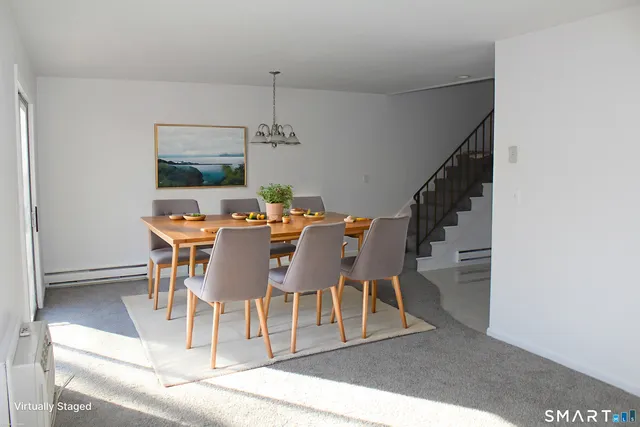a dining room with furniture a chandelier and wooden floor