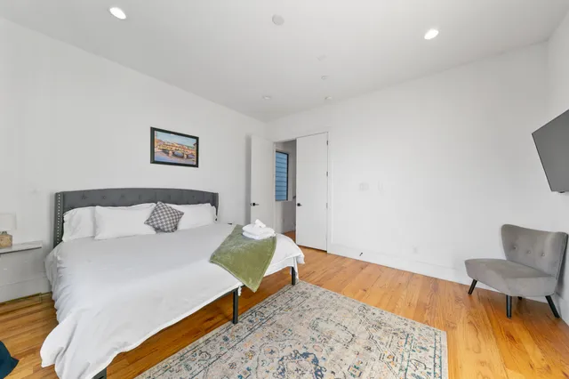 a spacious bedroom with a bed and a flat screen tv