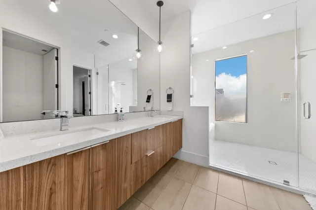 a bathroom with a tub a sink a mirror and a shower