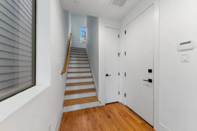 a view of a hallway with wooden floor and entryway