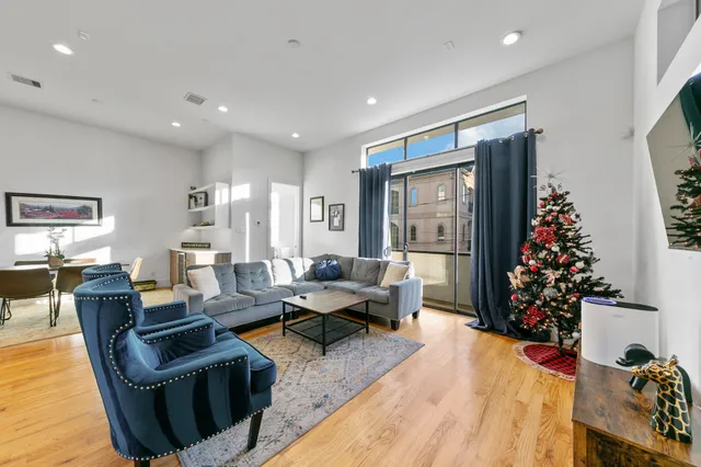 a living room with furniture potted plant and a wooden floor