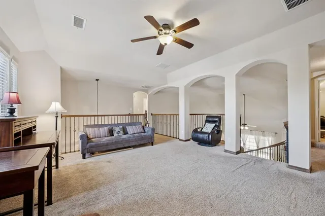 a view of a livingroom with furniture and a ceiling fan