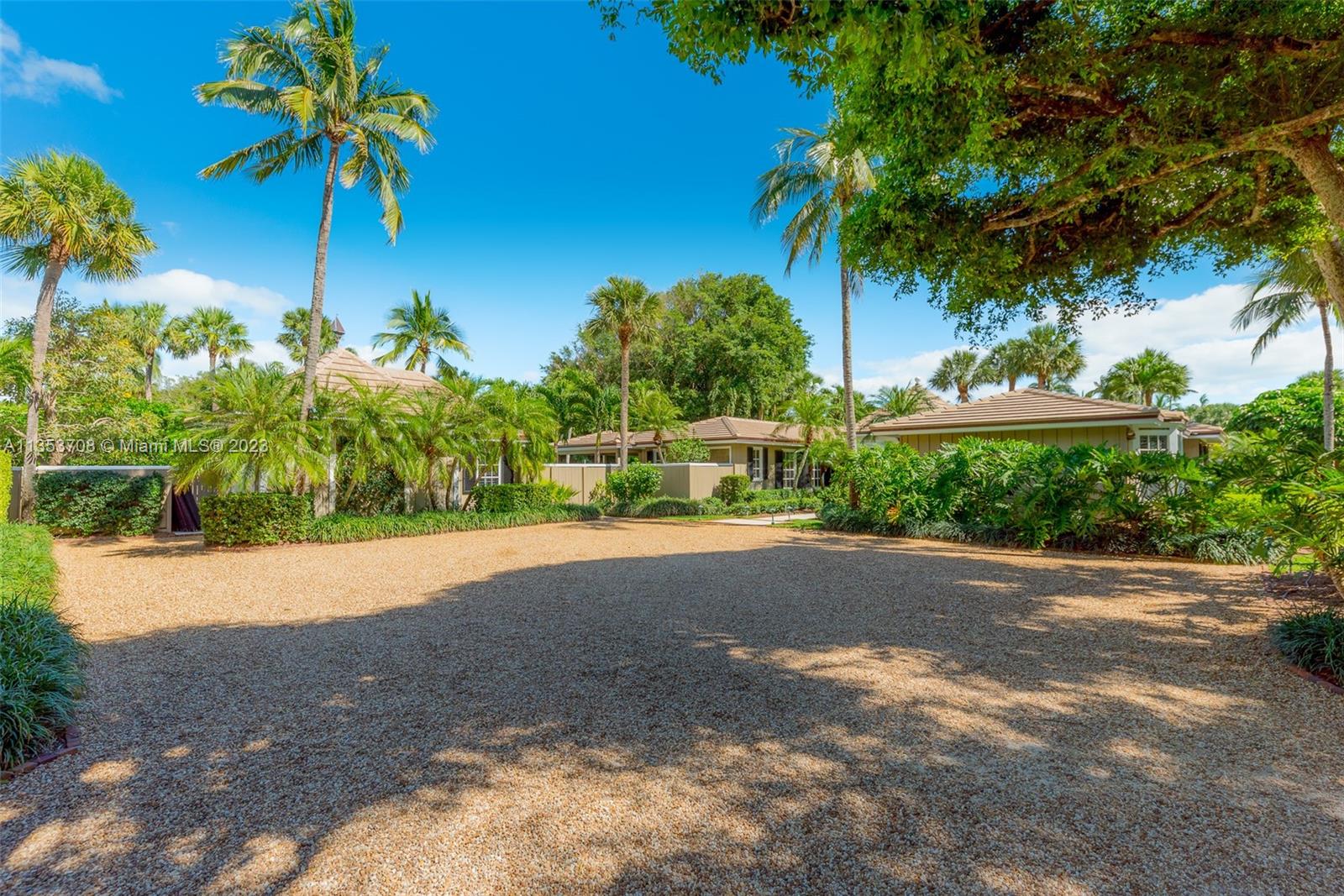 115 Gomez Road Jupiter Island, FL 33455 - Photo 16 of 20 a front view of a house with a yard and a garage