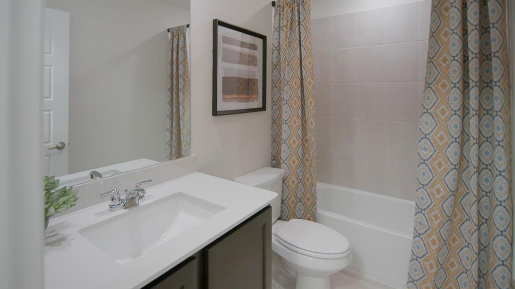 500 Range Road Caddo Mills, TX 75135 - Photo 5 of 35 Bathroom featuring a vanity with an integrated sink, polished chrome faucet, and dark wood-finish cabinetry