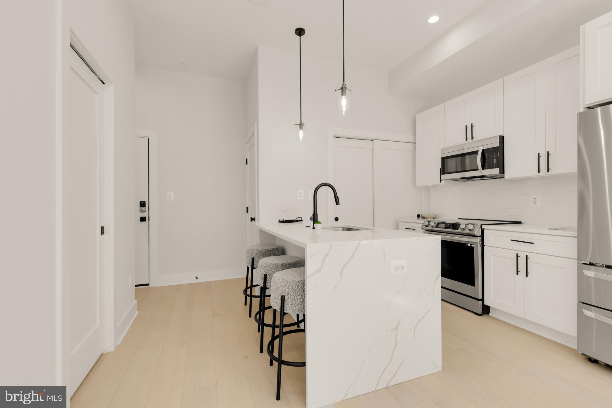 5505 7th Street Northwest, Unit 5 Washington, DC 20011 - Photo 6 of 27 a kitchen with stainless steel appliances a stove a sink and white cabinets