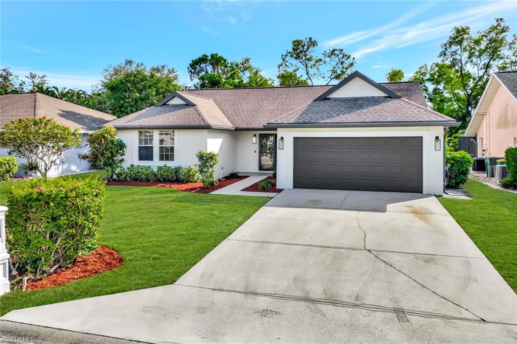 3650 Kent Drive Naples, FL 34112 - Photo 33 of 40 a front view of a house with a yard and potted plants