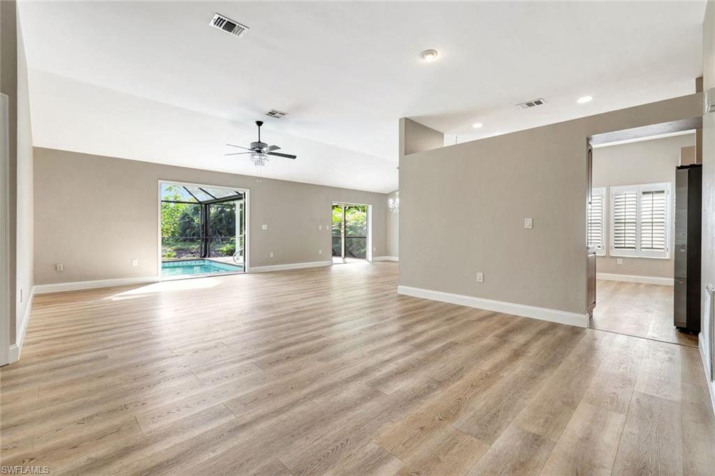 3650 Kent Drive Naples, FL 34112 - Photo 7 of 40 an empty room with wooden floor chandelier and windows