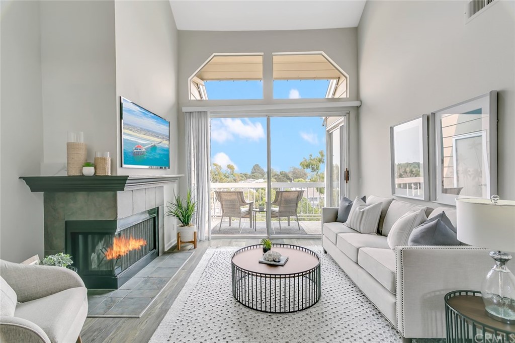 a living room with furniture a fireplace and a large window