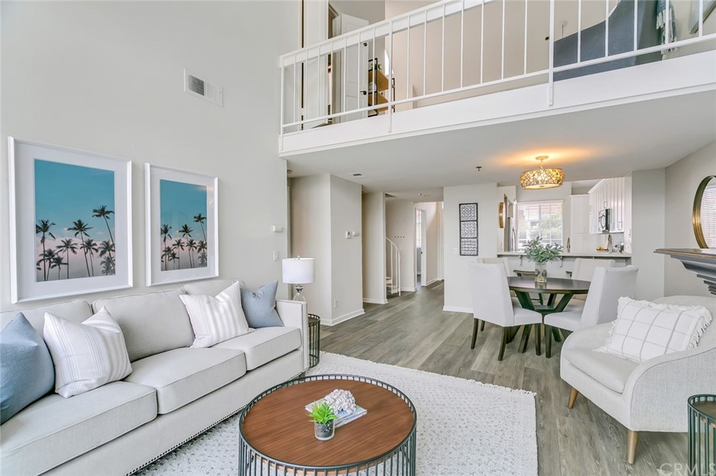 20331 Bluffside Circle, Unit A416 Huntington Beach, CA 92646 - Photo 12 of 42 a living room with furniture a rug and a dining table