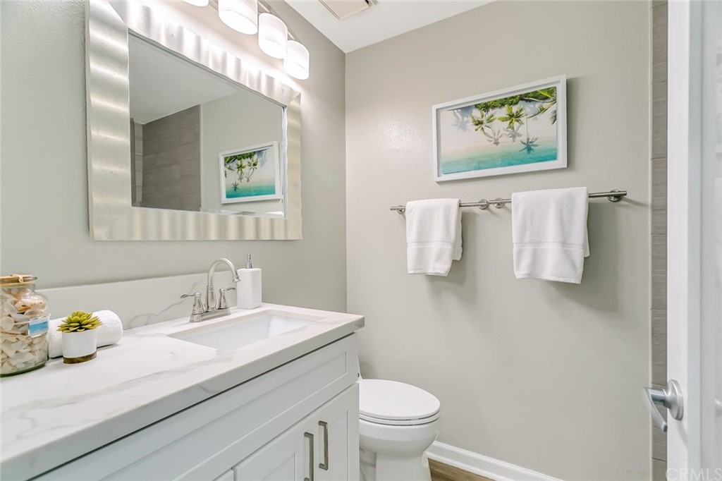 20331 Bluffside Circle, Unit A416 Huntington Beach, CA 92646 - Photo 19 of 42 a bathroom with a toilet sink and mirror