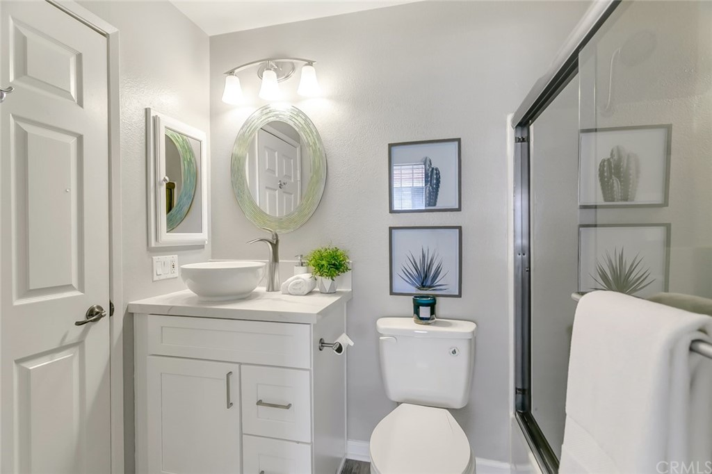 20331 Bluffside Circle, Unit A416 Huntington Beach, CA 92646 - Photo 23 of 42 a bathroom with a toilet a sink and a mirror