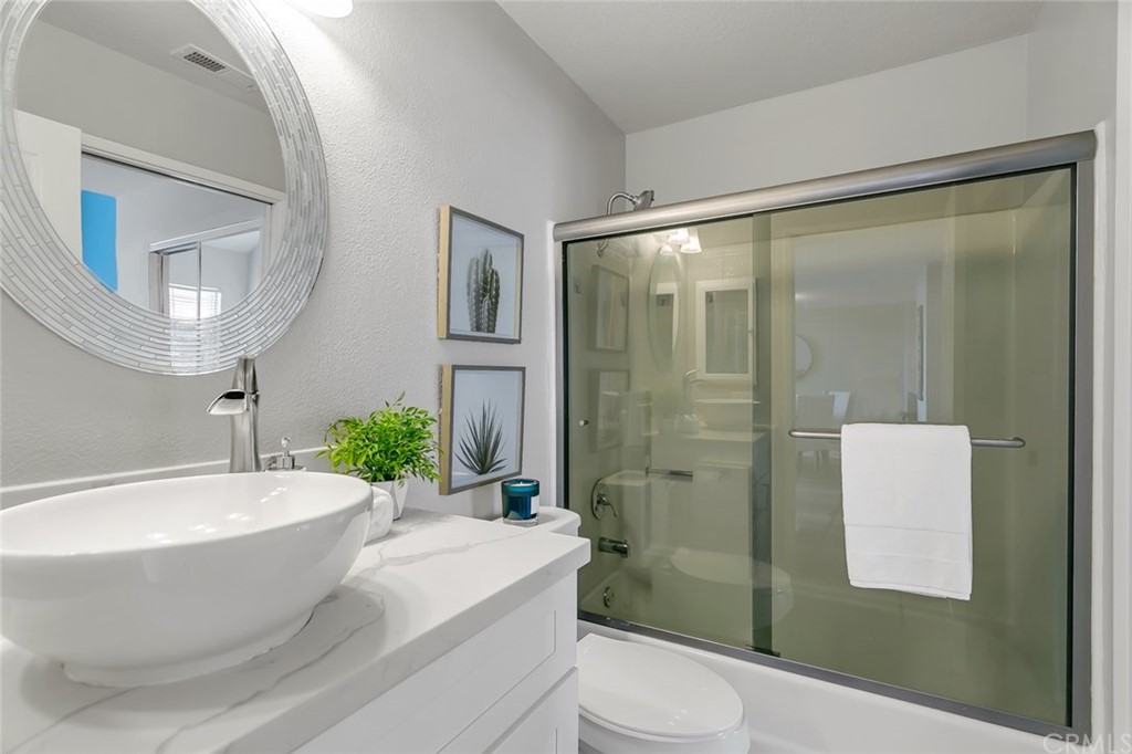 20331 Bluffside Circle, Unit A416 Huntington Beach, CA 92646 - Photo 24 of 42 a bathroom with a white tub shower vanity and a sink