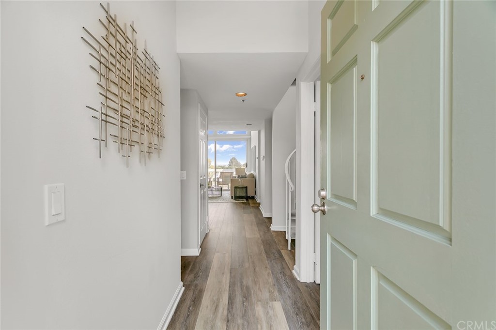 20331 Bluffside Circle, Unit A416 Huntington Beach, CA 92646 - Photo 4 of 42 a view of a hallway with wooden floor and staircase