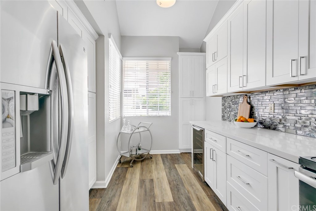 20331 Bluffside Circle, Unit A416 Huntington Beach, CA 92646 - Photo 7 of 42 a kitchen with white cabinets and white appliances
