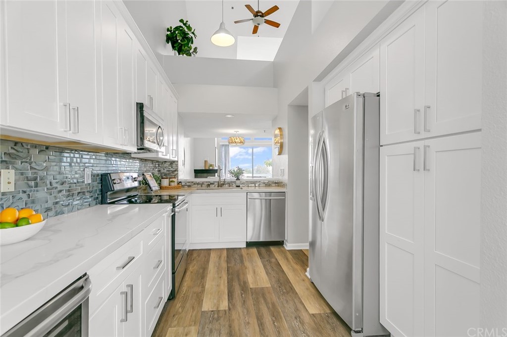 20331 Bluffside Circle, Unit A416 Huntington Beach, CA 92646 - Photo 9 of 42 a kitchen with a sink a refrigerator and cabinets