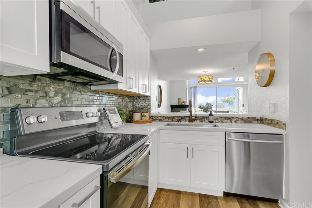 20331 Bluffside Circle, Unit A416 Huntington Beach, CA 92646 - Photo 10 of 42 a kitchen with stainless steel appliances granite countertop a stove and a sink