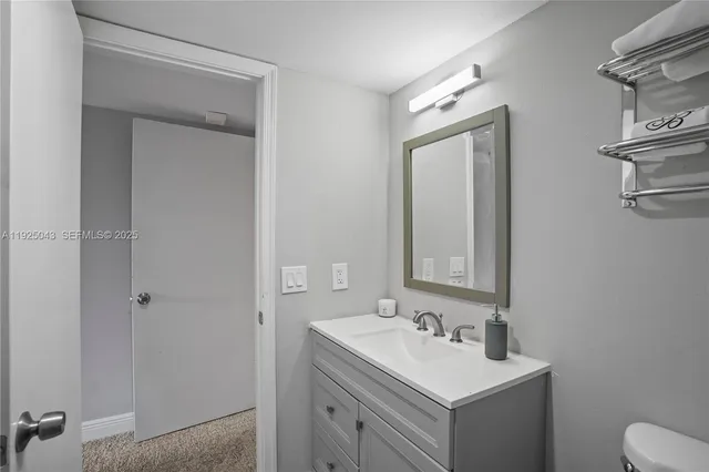 a bathroom with a sink toilet and mirror