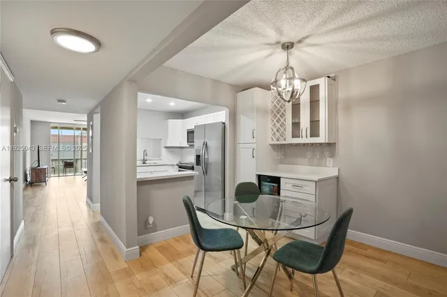 a kitchen with stainless steel appliances a dining table chairs and granite counter tops