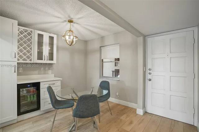 a dining room with wooden floor a chandelier a wooden table and chairs