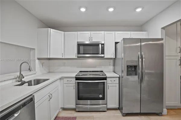a kitchen with refrigerator a microwave and sink