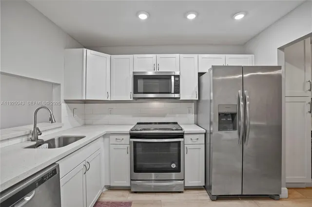 a kitchen with refrigerator a microwave and sink