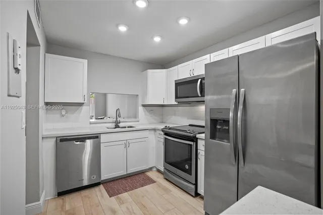 a kitchen with a sink stainless steel appliances and cabinets