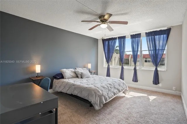 a bedroom with two beds and ceiling fan