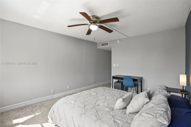 a bedroom with a large bed and a ceiling fan
