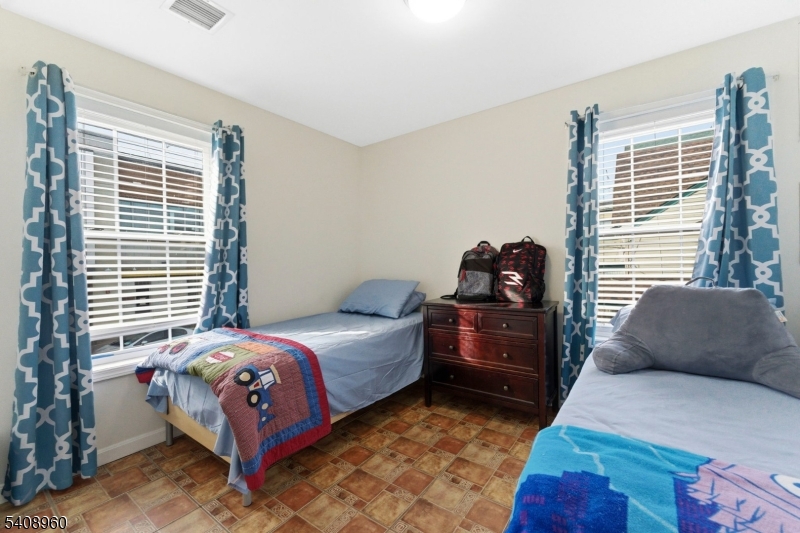29 22nd Avenue Paterson, NJ 07513 - Photo 12 of 20 a bedroom with a bed and a window