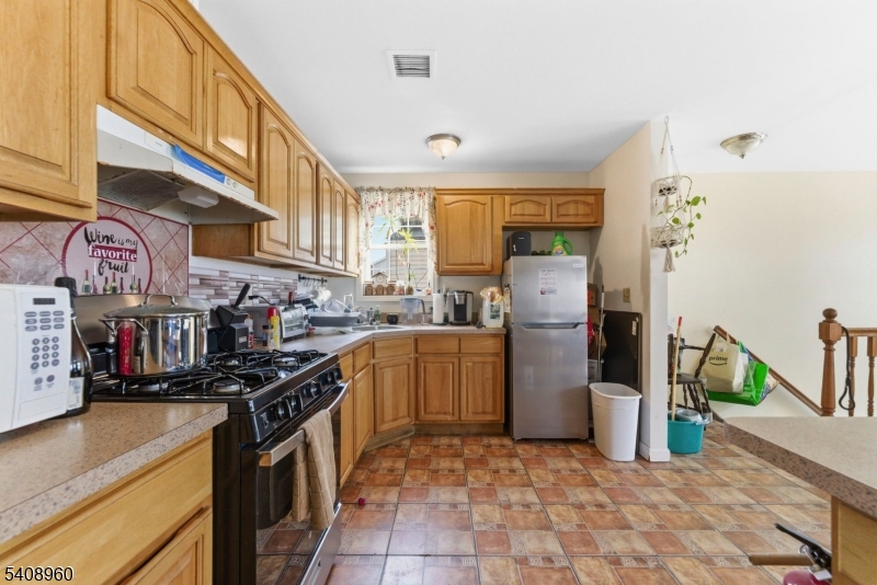 29 22nd Avenue Paterson, NJ 07513 - Photo 19 of 20 a kitchen with stainless steel appliances granite countertop a sink stove and refrigerator