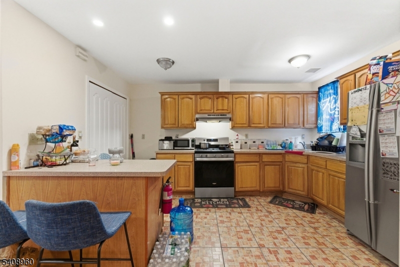 29 22nd Avenue Paterson, NJ 07513 - Photo 5 of 20 a kitchen with granite countertop a sink stove and refrigerator