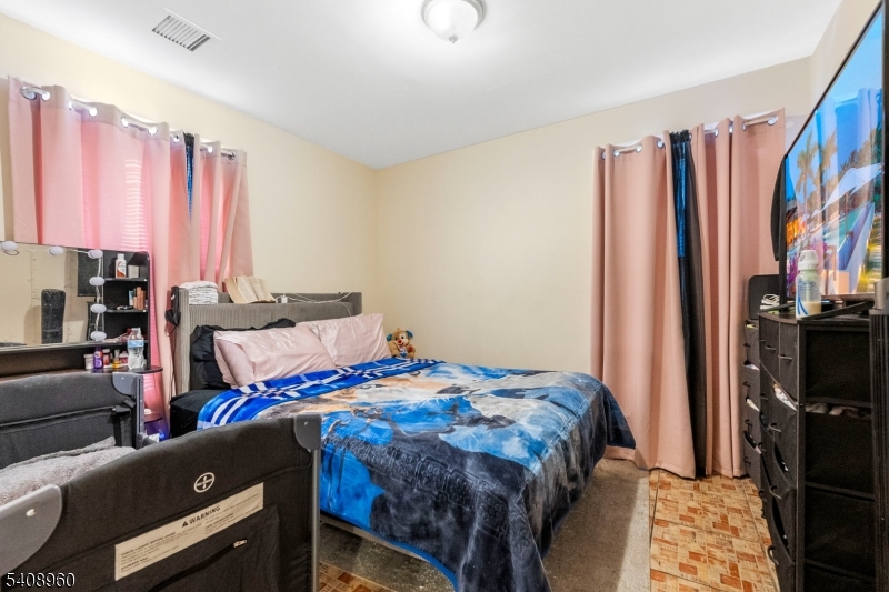 29 22nd Avenue Paterson, NJ 07513 - Photo 8 of 20 a bedroom with a bed and a closet