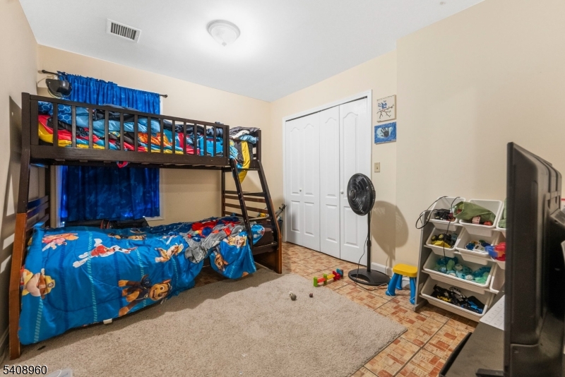 29 22nd Avenue Paterson, NJ 07513 - Photo 9 of 20 a bedroom with a bed a dresser and a book shelf