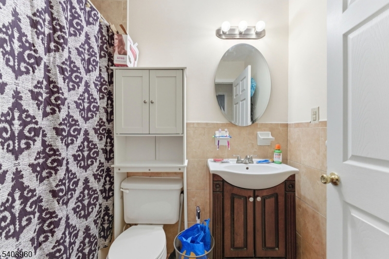 29 22nd Avenue Paterson, NJ 07513 - Photo 10 of 20 a bathroom with a sink and a mirror with toilet