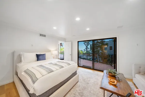 a bedroom with a bed a fireplace and a large window