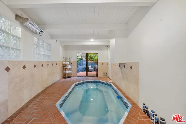 a bedroom with furniture large window and flat screen tv