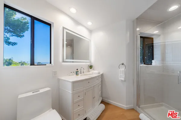 a bathroom with a sink mirror vanity and toilet