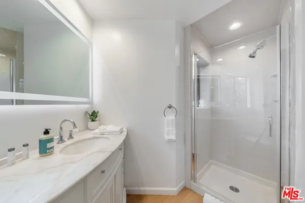 a bathroom with a tub a sink and a large mirror