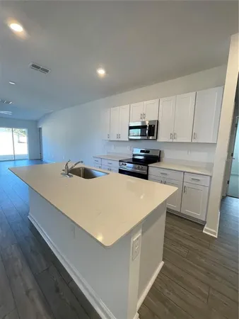 a kitchen with stainless steel appliances a white stove top oven sink and cabinets