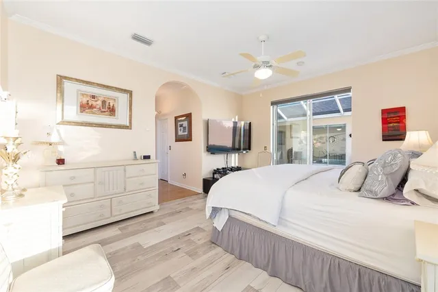 a bedroom with a bed and a flat tv screen on dresser