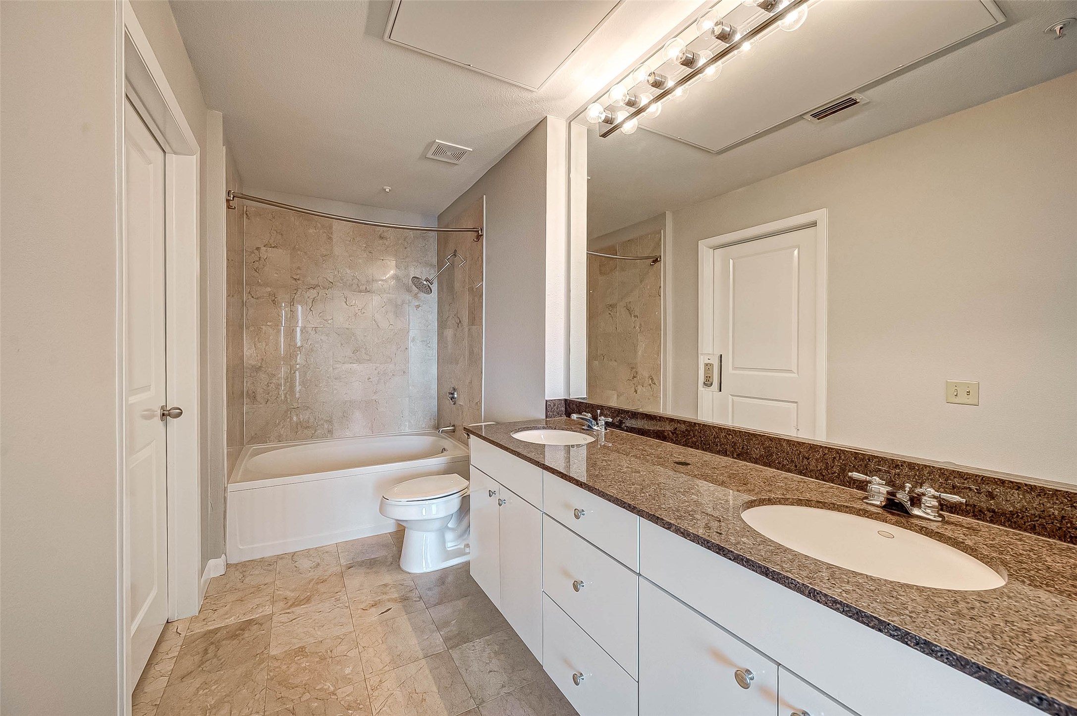 3505 Sage Road, Unit 2106 Houston, TX 77056 - Photo 20 of 28 a bathroom with a granite countertop double vanity sink a mirror and a bathtub