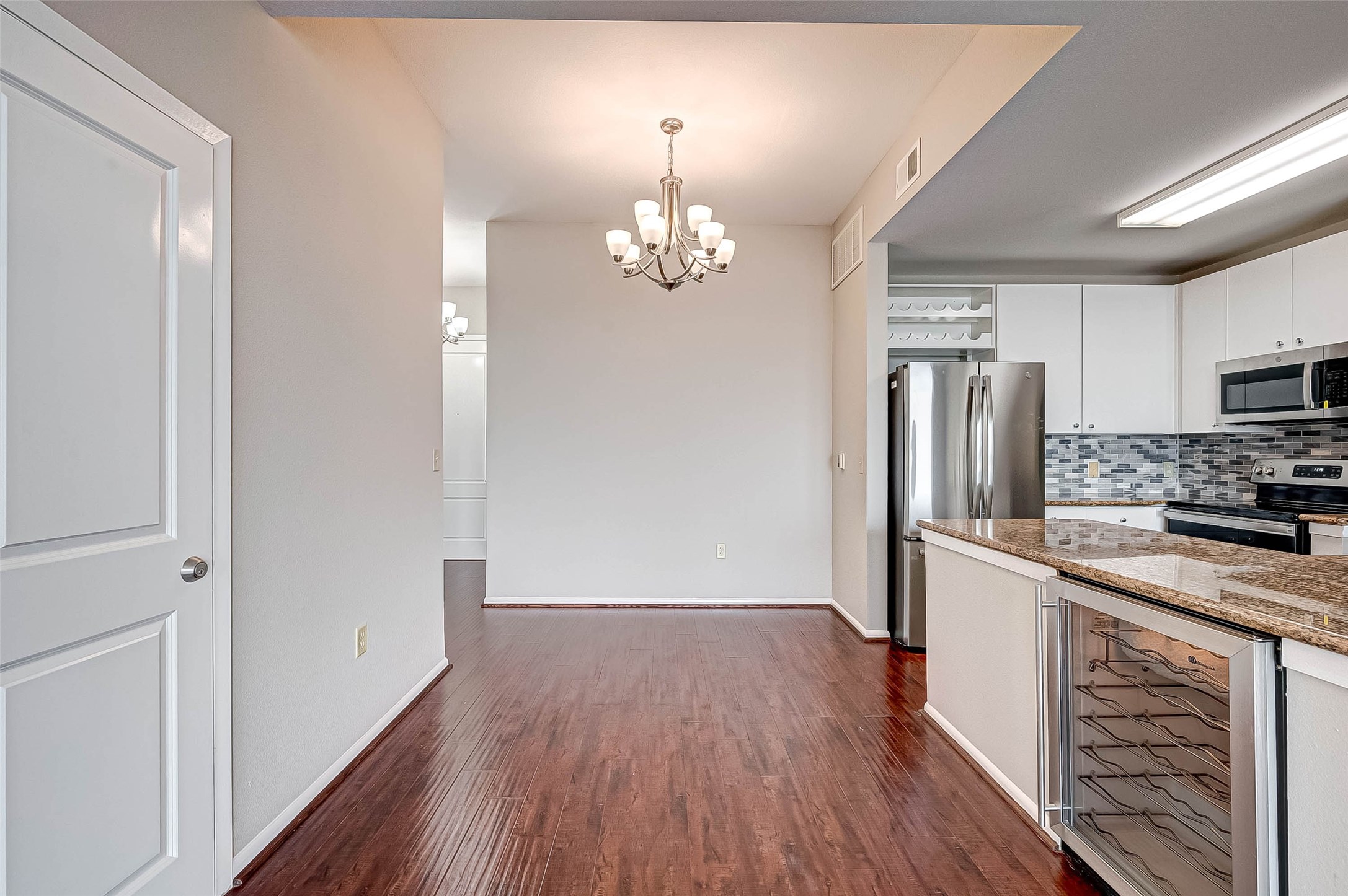 3505 Sage Road, Unit 2106 Houston, TX 77056 - Photo 3 of 28 a kitchen with kitchen island wooden floors appliances and cabinets