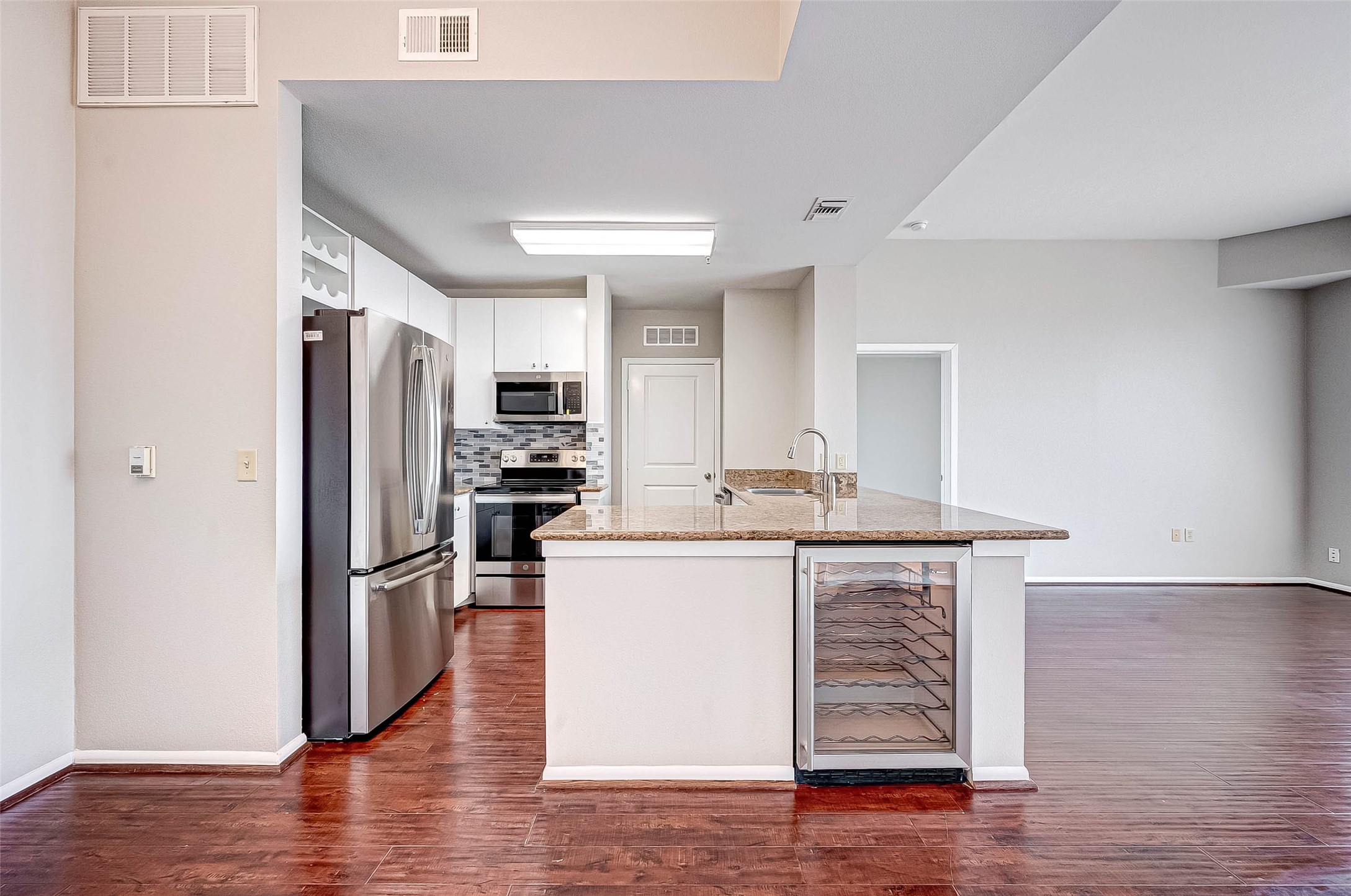 3505 Sage Road, Unit 2106 Houston, TX 77056 - Photo 4 of 28 a kitchen with stainless steel appliances a refrigerator and wooden floor
