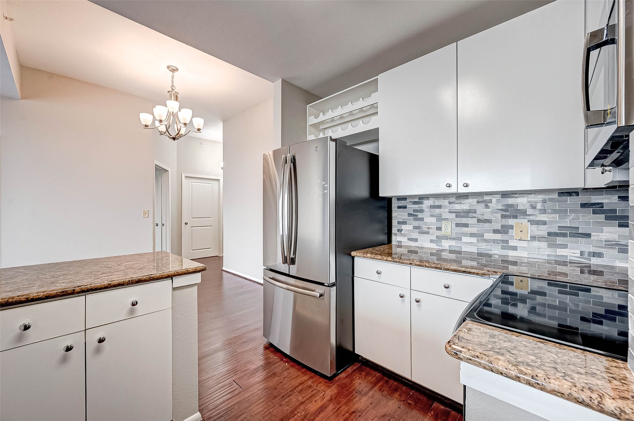 3505 Sage Road, Unit 2106 Houston, TX 77056 - Photo 6 of 28 a kitchen with granite countertop a refrigerator and a stove top oven