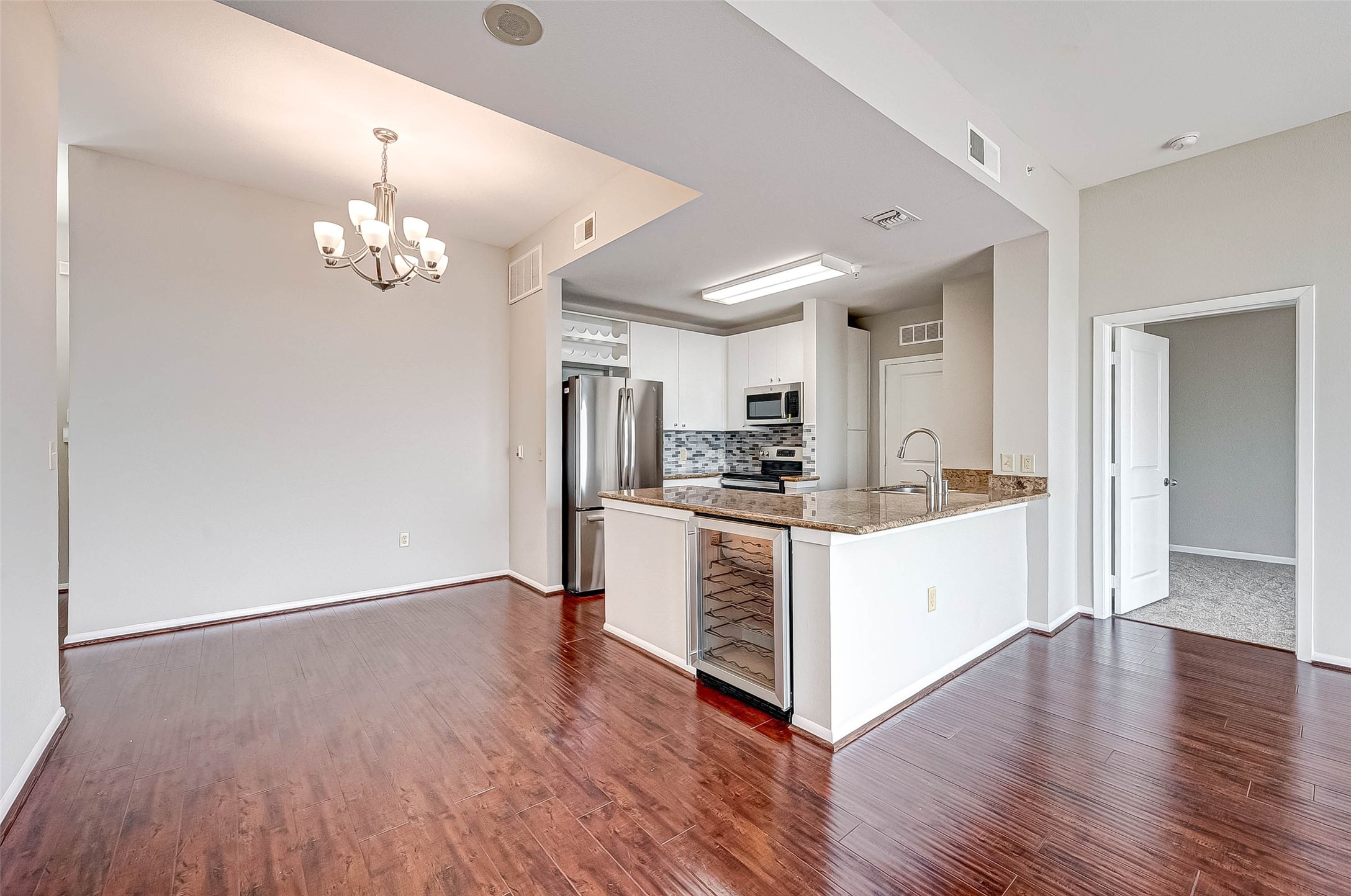 3505 Sage Road, Unit 2106 Houston, TX 77056 - Photo 7 of 28 a large white kitchen with a refrigerator and wooden floor
