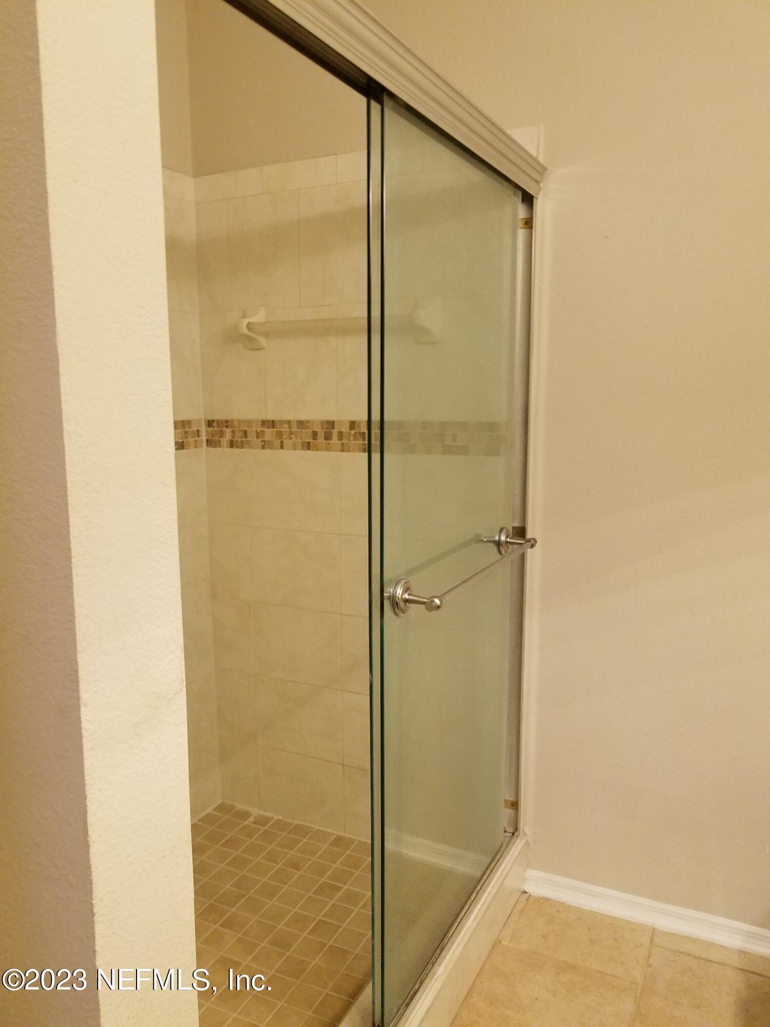 13810 Sutton Park Drive North, Unit 124 Jacksonville, FL 32224 - Photo 7 of 12 a bathroom with a glass shower door